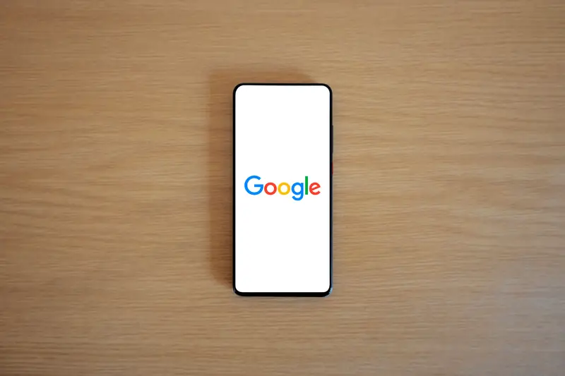 Smartphone displaying Google search on a wooden desk